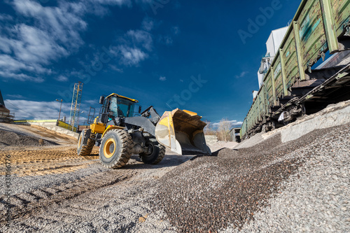 Wheel loader picks rubble into the bucket. Work on a flyover for unloading railway freight cars. photo