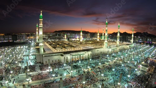 Muslim pilgrims leave and enter the Prophet's mosque in Madina at sunset, religion in Saudi Arabia photo