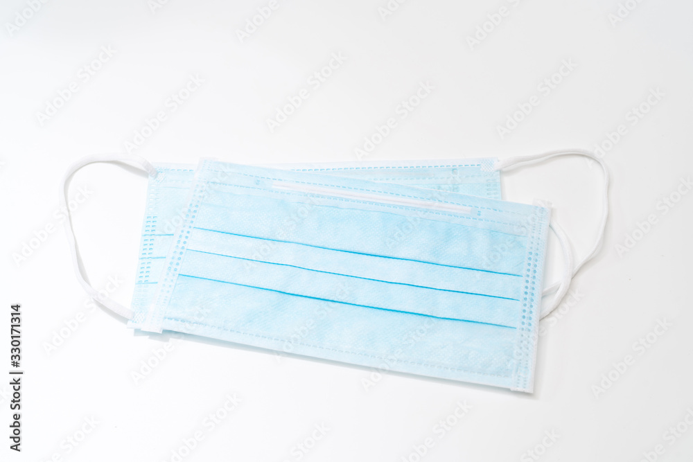 Surgical mask with rubber ear straps. Typical 3-ply surgical mask to cover the mouth and nose. Procedure mask from bacteria. Protection concept. Surgical mask with rubber ear straps. Typical 3-ply surgical mask to cover the mouth and nose. Procedure mask from bacteria. Protection concept.