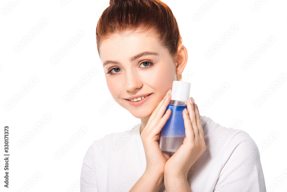 happy teenager with clean skin holding bottle with blue makeup remover, isolated on white happy teenager with clean skin holding bottle with blue makeup remover, isolated on white