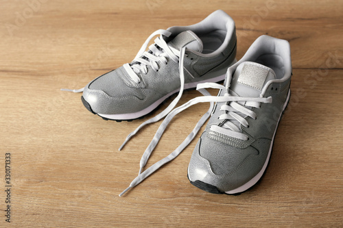 New gray sneakers on a light wooden background