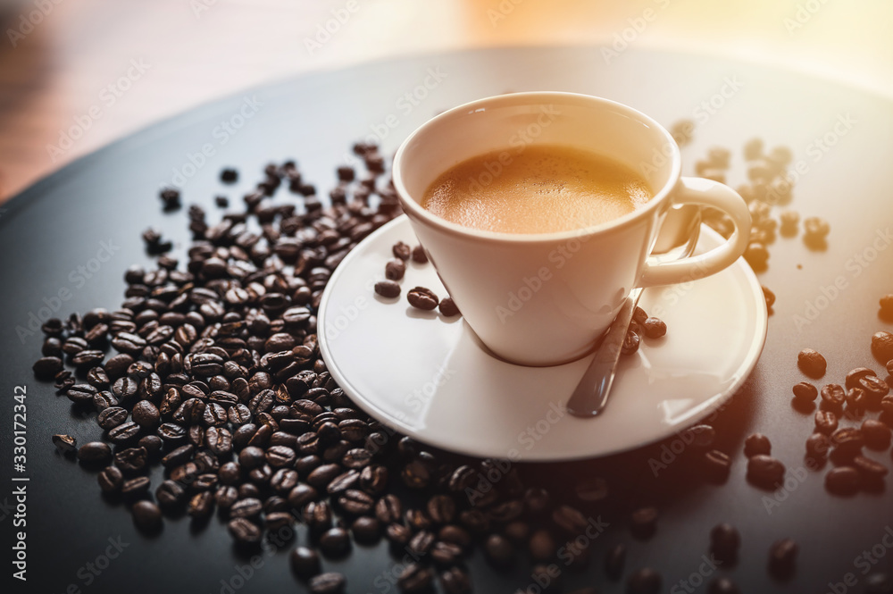Obraz premium Coffee and coffee beans on black table. Coffee beams closeup. Coffee theme. White cup on black table.
