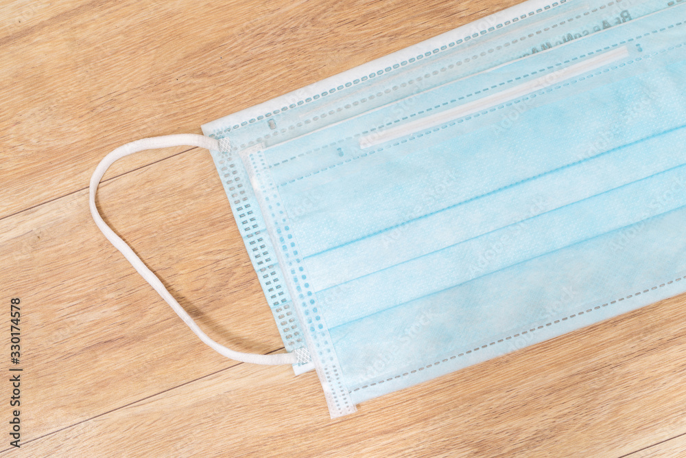 Surgical mask with rubber ear straps. Typical 3-ply surgical mask to cover the mouth and nose. Procedure mask from bacteria. Protection concept. Surgical mask with rubber ear straps. Typical 3-ply surgical mask to cover the mouth and nose. Procedure mask from bacteria. Protection concept.