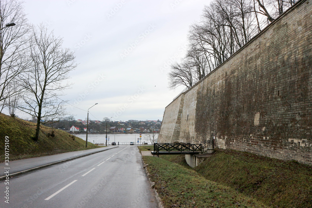Obraz premium Road to river Narva embankment with old bastion on the side