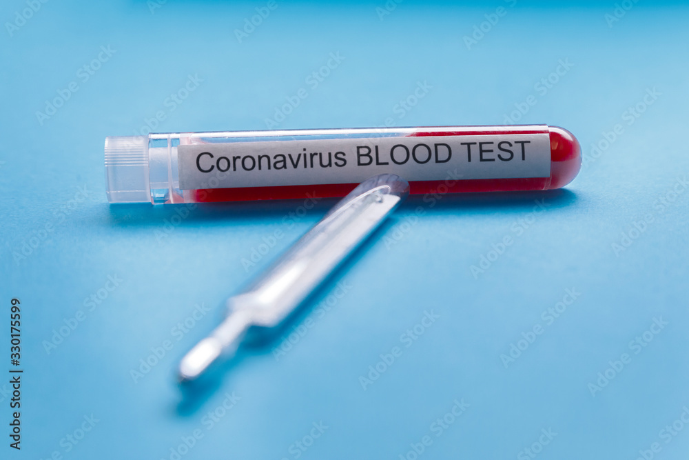 Obraz premium termometro e fiala per il controllo del sangue su coronavir- sfondo blu