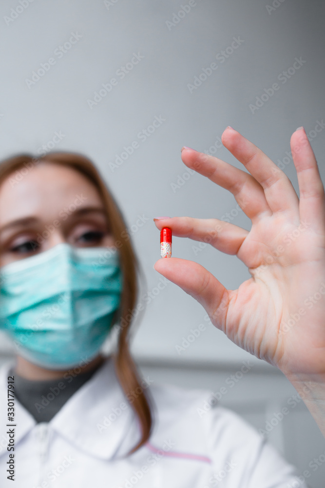 Health safety and medicine concept - beautiful girl doctor holds pill for disease Health safety and medicine concept - beautiful girl doctor holds pill for disease