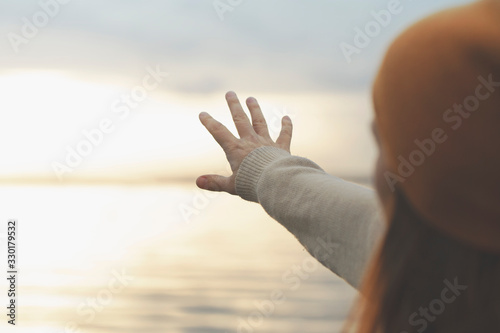 woman tries to touch the sun with her hand
