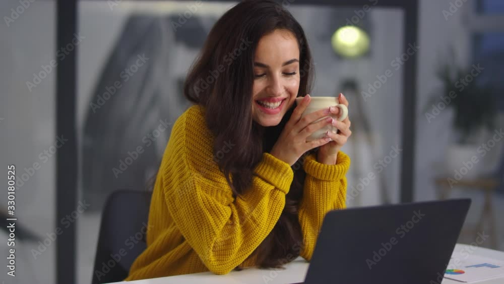 Closeup business woman looking laptop. Smiling girl drinking tea near notebook