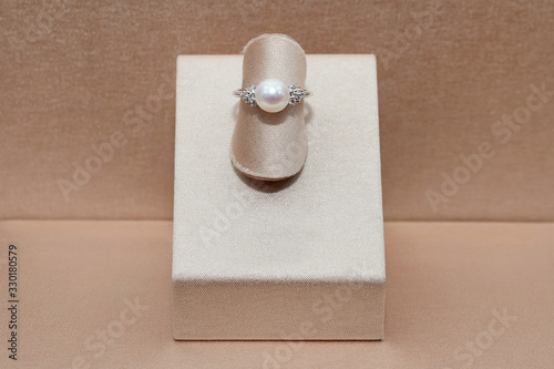 Beautiful diamond gold ring with shine sphere pearl displayed on a stand. Luxury jewelry