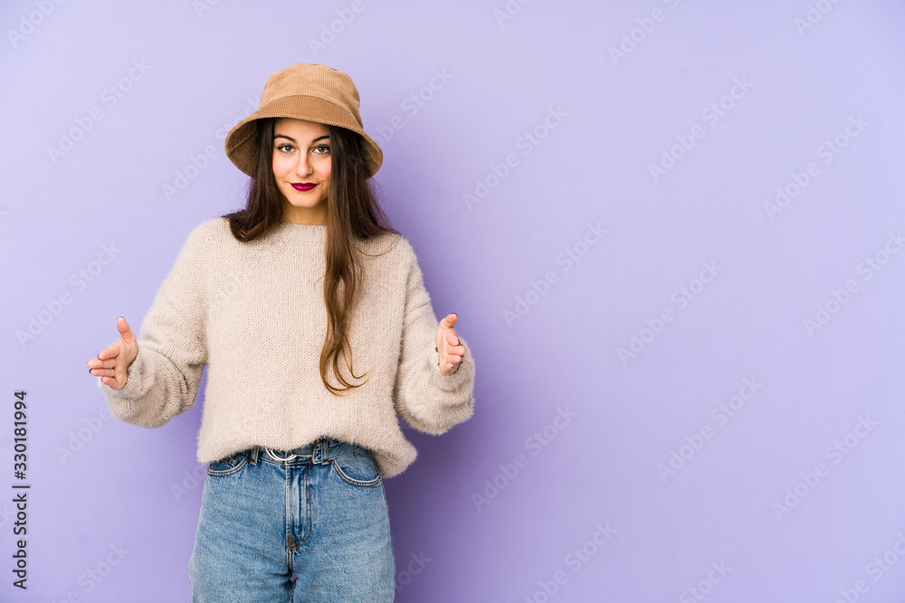 Young caucasian woman isolated on purple background holding something with both hands, product presentation. Young caucasian woman isolated on purple background holding something with both hands, product presentation.