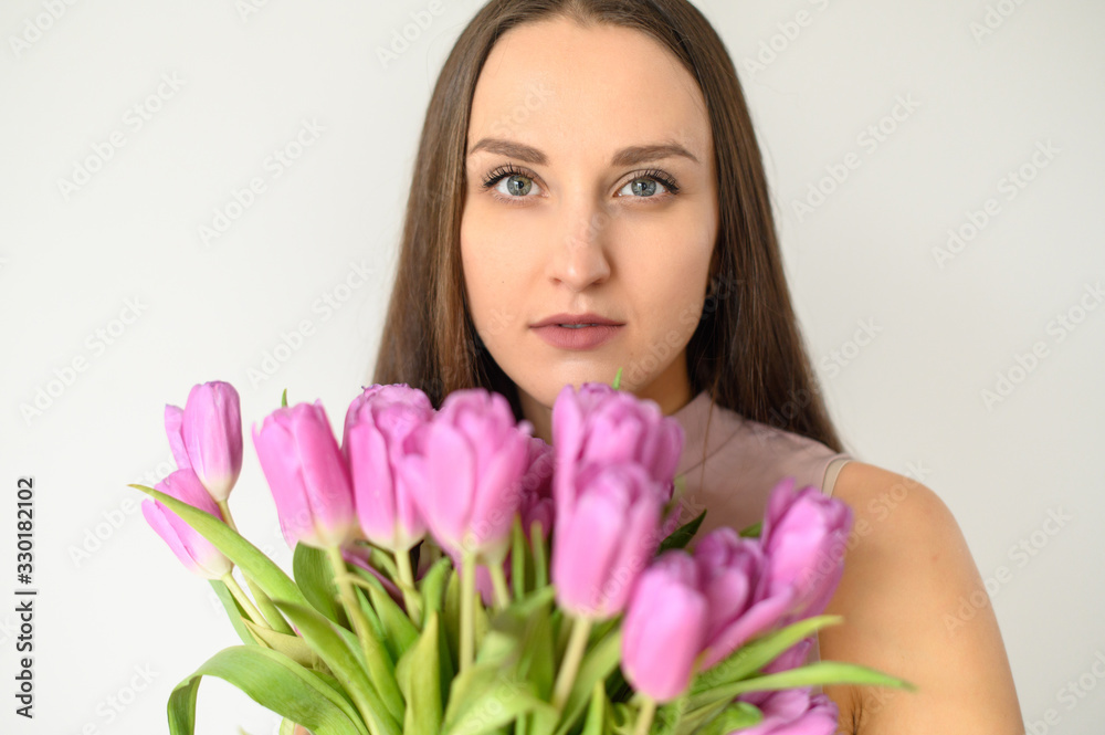 Spring mood. Beautiful woman with tulips indoors