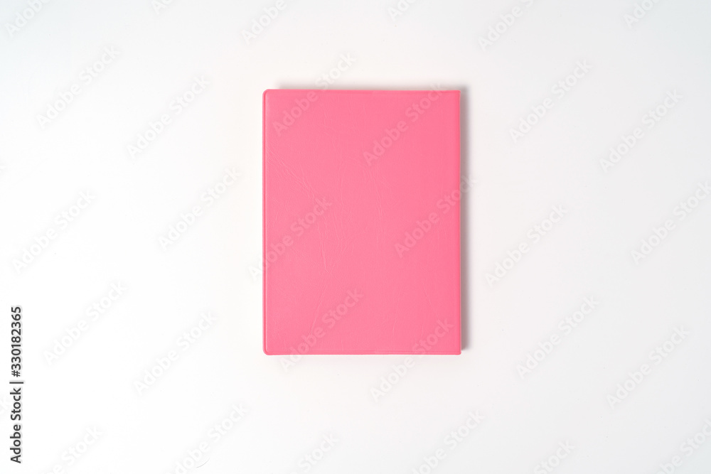 Pink notebook on white desk. Business minimal concept for women. Flat lay, top view, copy space Pink notebook on white desk. Business minimal concept for women. Flat lay, top view, copy space