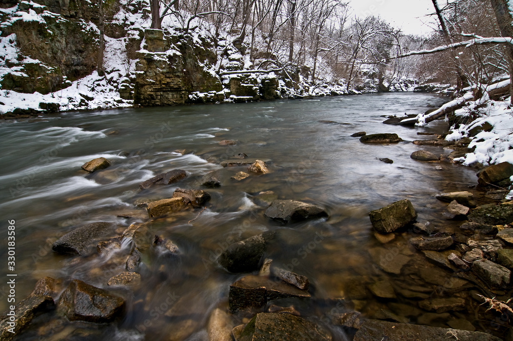 A picturesque stream flows through a pristine Midwest winter landscape.