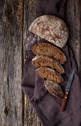 Freshly baked wheat bread, homemade cakes, still life with bread, crisp loaf of bread, still life on a rustic background, top view, rustic bread, roll, loaf. photo