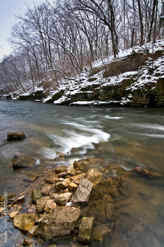 A picturesque stream flows through a pristine Midwest winter landscape.