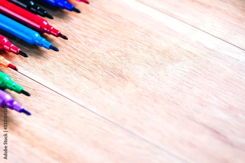 multicolored pencils on the wooden table background