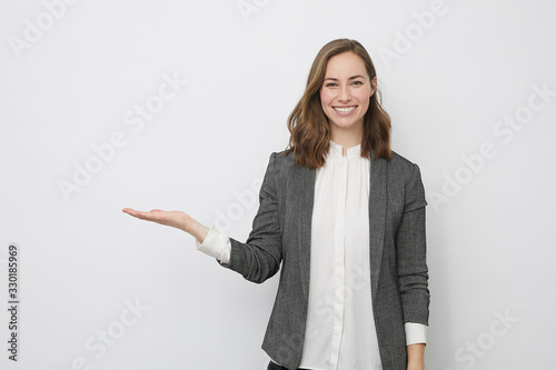 Beautiful businesswoman is looking happy and presenting your product photo