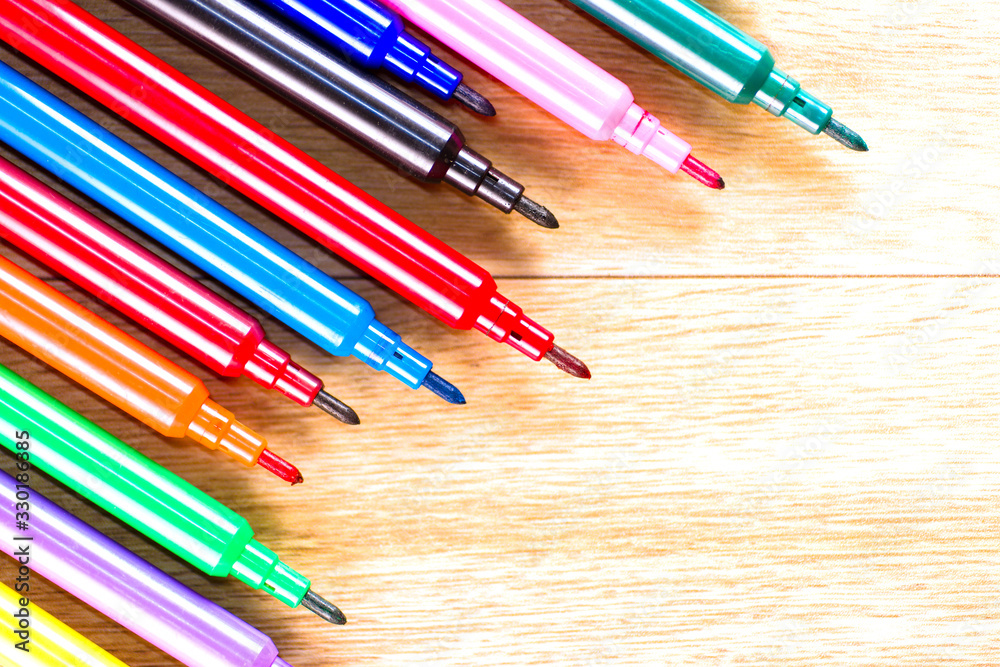 multicolored pencils on the wooden table background