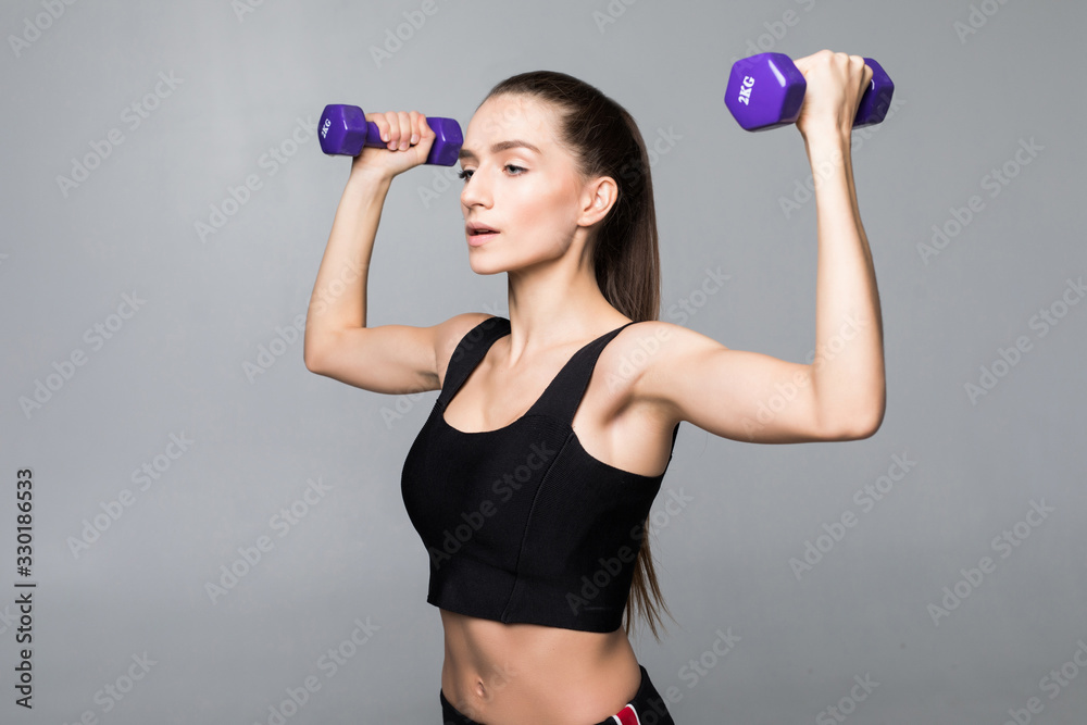 Smiling fitness woman workout with small dumbbells isolated on white background Smiling fitness woman workout with small dumbbells isolated on white background