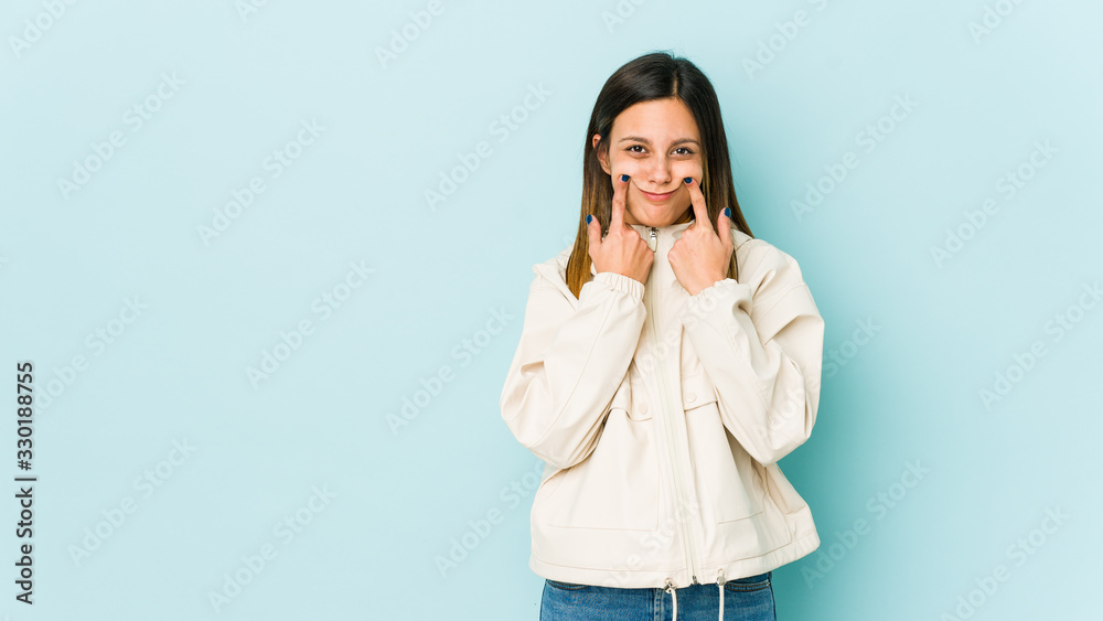 Young woman isolated on blue background doubting between two options. Young woman isolated on blue background doubting between two options.