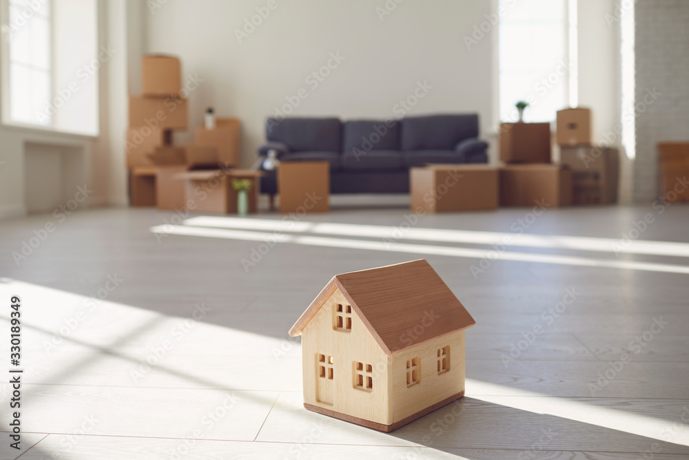 Model of the wooden house on the floor in the new bright sunny house. Model of the wooden house on the floor in the new bright sunny house.