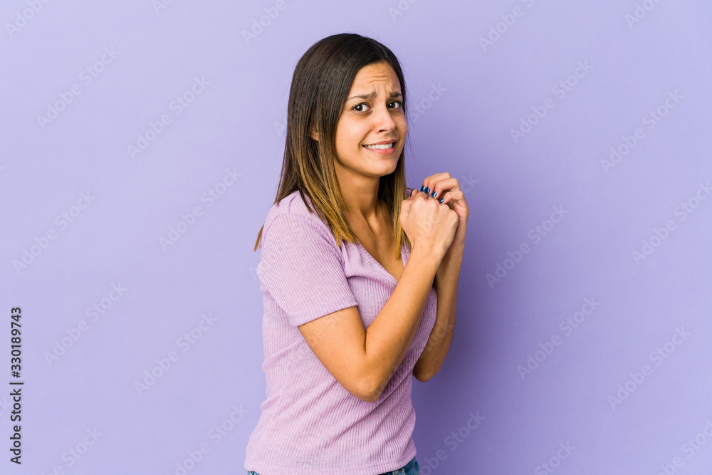 Young woman isolated on purple background scared and afraid. Young woman isolated on purple background scared and afraid.
