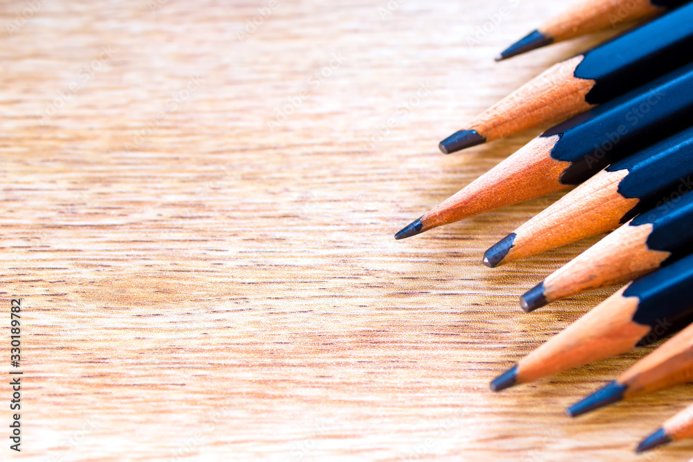 Obraz premium black pencils isolated on wood surface background.Close up.