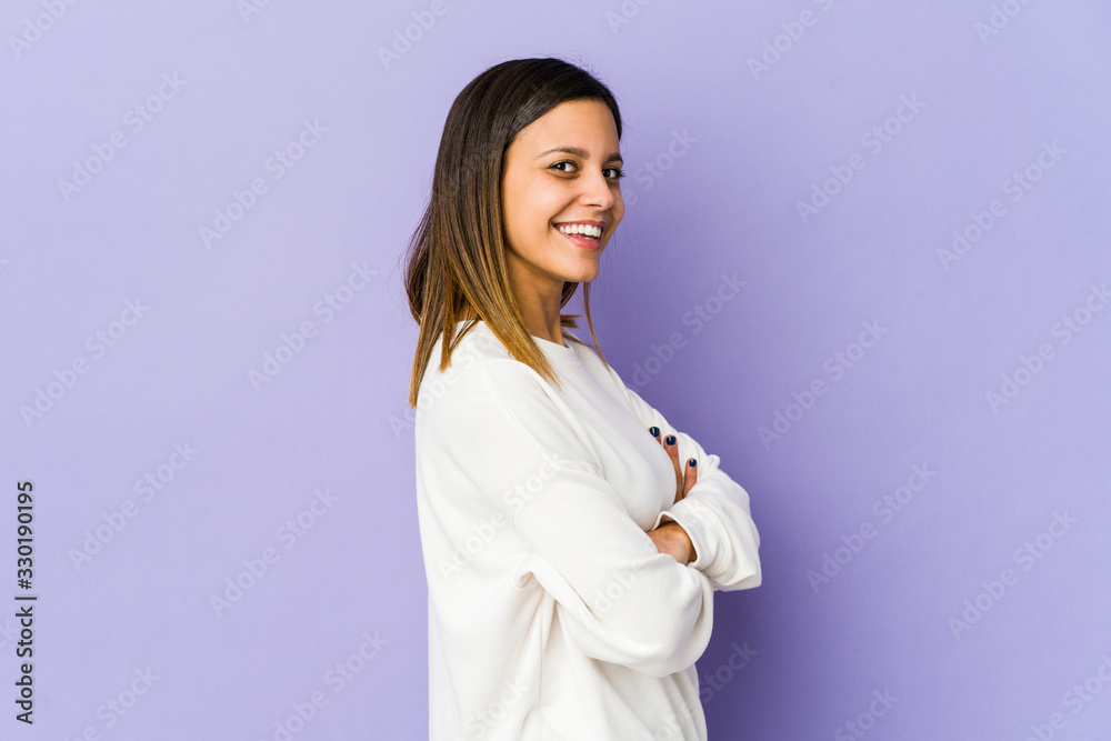 Young woman isolated on purple background who feels confident, crossing arms with determination. Young woman isolated on purple background who feels confident, crossing arms with determination.
