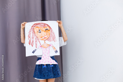 Little prescholer girl holding her portrait picture photo