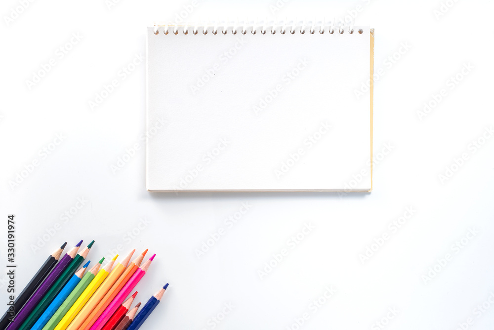 notepad with color pencil on white table view from above notepad with color pencil on white table view from above