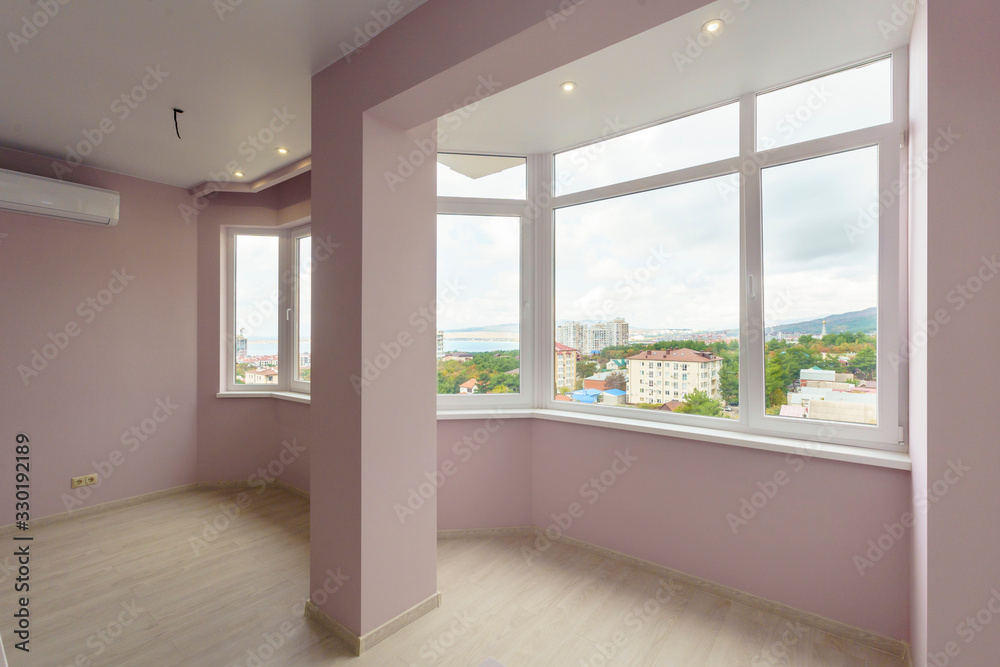A room in a new building with a fresh renovation. The walls are pink, the floors A room in a new building with a fresh renovation. The walls are pink, the floors