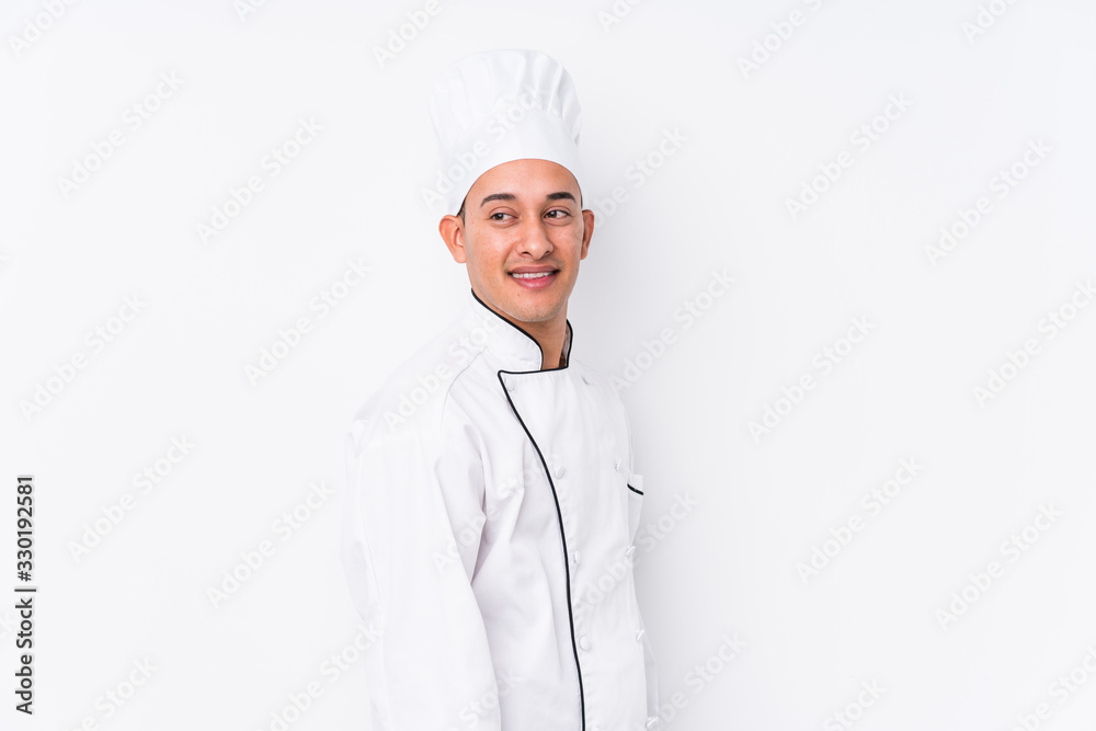 Young latin chef man isolated looks aside smiling, cheerful and pleasant. Young latin chef man isolated looks aside smiling, cheerful and pleasant.