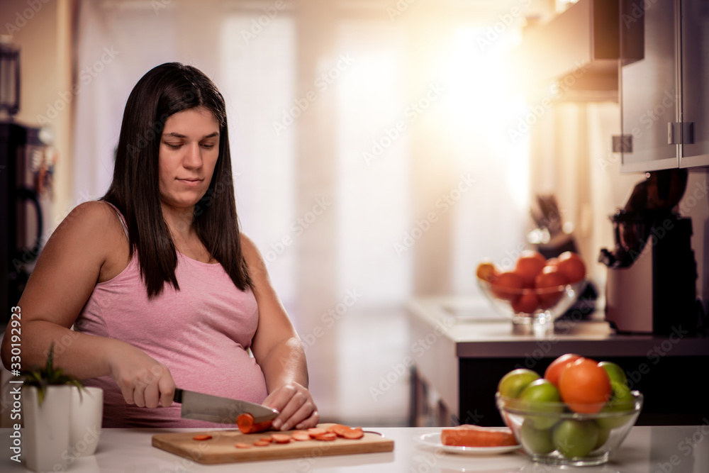 Pregnant woman preparing healthy food in kitchen. Pregnant woman preparing healthy food in kitchen.
