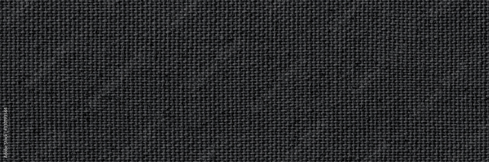 Closeup texture of natural weave cloth in dark gray or black color. Fabric texture of natural cotton or linen textile material. Wide and long panoramic background.