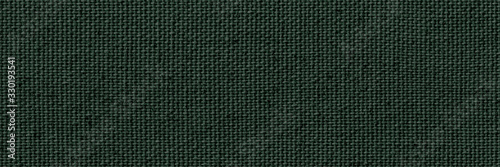 Blank, uncoated canvas or scrim for background. Long and wide panoramic banner background from rough linen dark green cloth or burlap.