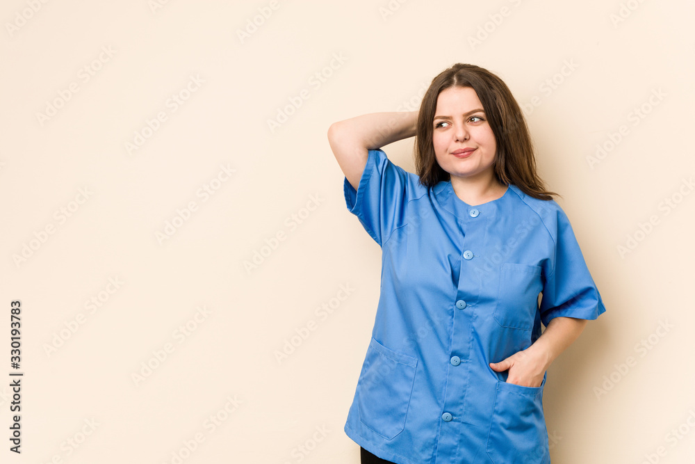Young curvy nurse woman touching back of head, thinking and making a choice. Young curvy nurse woman touching back of head, thinking and making a choice.