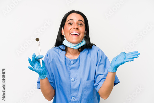 Dentist woman isolated on white background receiving a pleasant surprise  excited and raising hands.