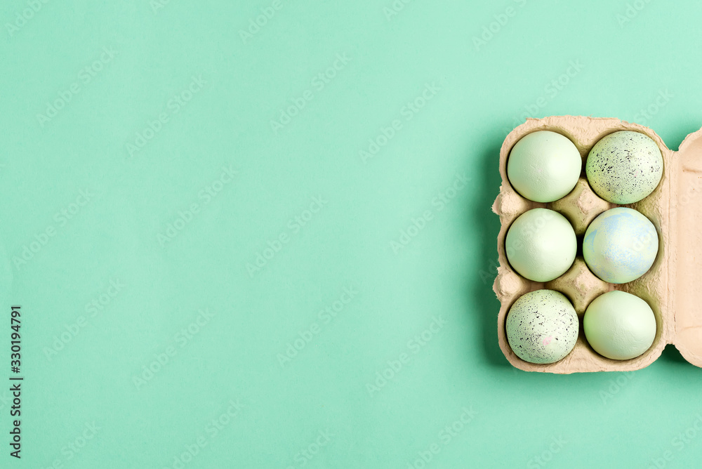Festive Easter frame from paper box of handmade green painted eggs on a green color background. Festive Easter frame from paper box of handmade green painted eggs on a green color background.
