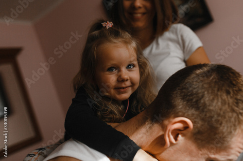 The portrait of the little girl embracing her father's neck