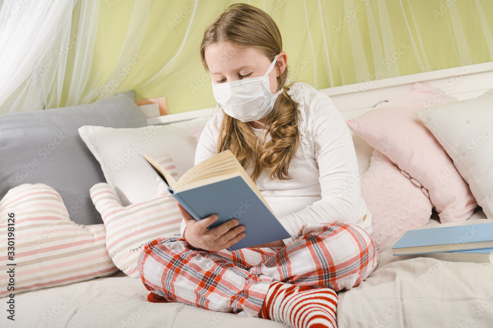 Girl reading a book during quarantine on the bed.