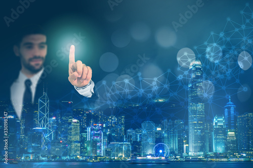 Photography Businessman pointing on screen with background of Hong Kong city, connection network lines and light bokeh