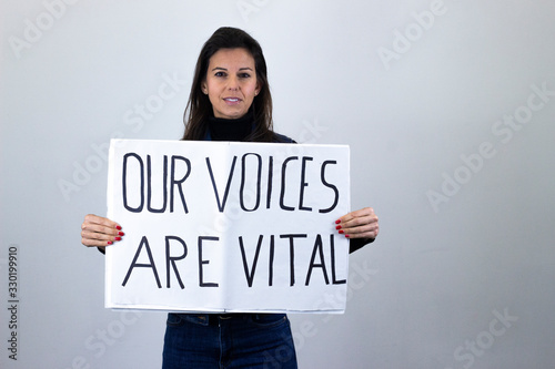 attractive  middle age woman activist hold up protesting sign saying 