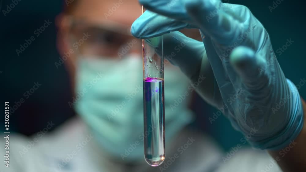 scientist pouring chemical substance into test tube, observing reaction scientist pouring chemical substance into test tube, observing reaction