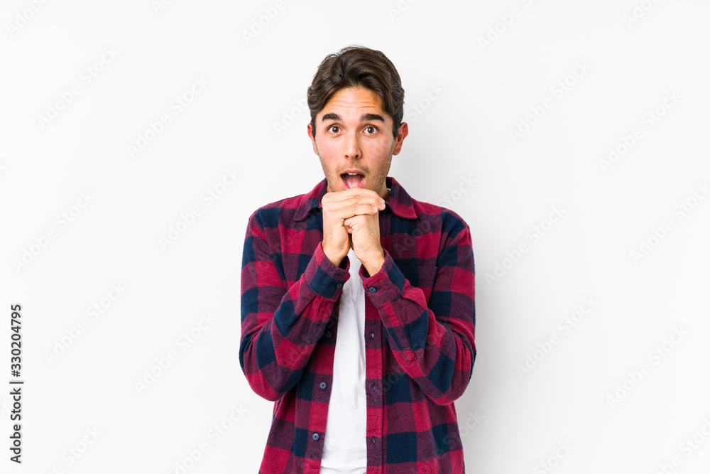 Young caucasian man posing in a pink background isolated praying for luck, amazed and opening mouth looking to front. Young caucasian man posing in a pink background isolated praying for luck, amazed and opening mouth looking to front.
