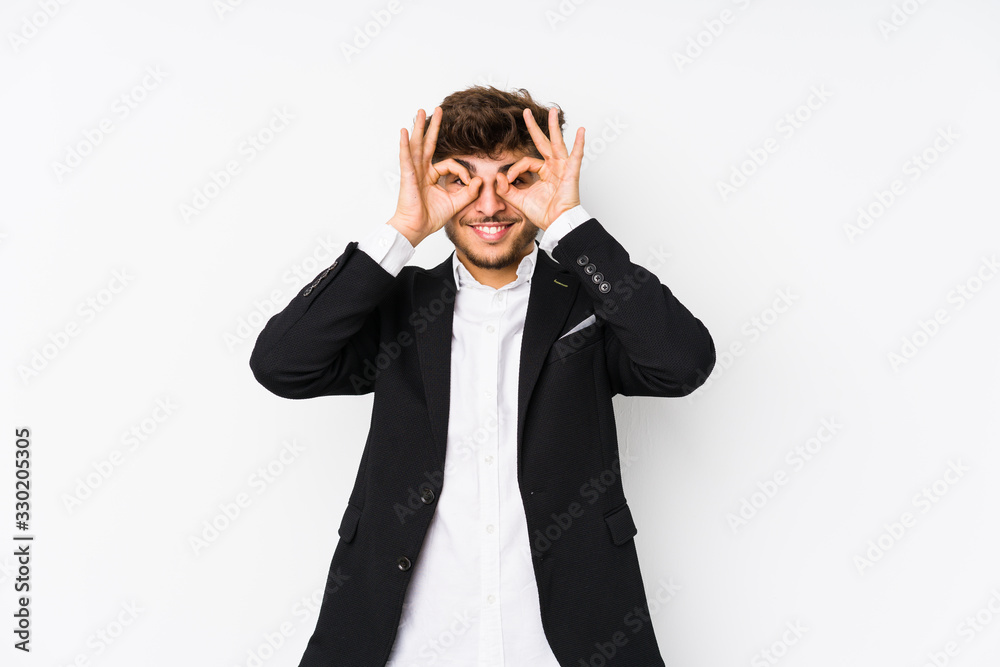 Young arabian business man isolated showing okay sign over eyes Young arabian business man isolated showing okay sign over eyes