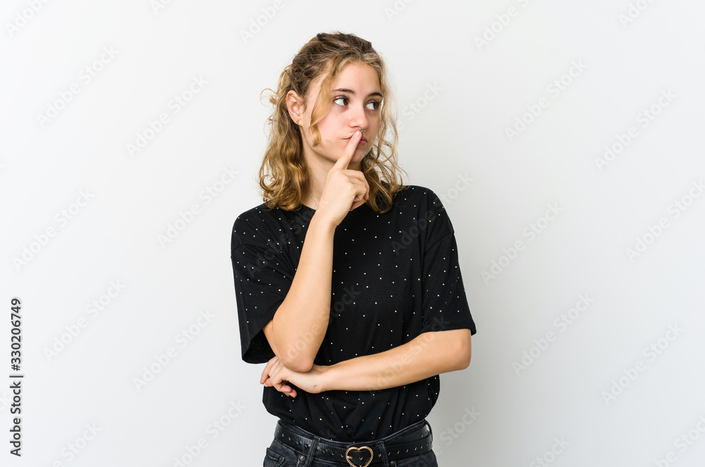 Young caucasian woman on white backrgound looking sideways with doubtful and skeptical expression. Young caucasian woman on white backrgound looking sideways with doubtful and skeptical expression.