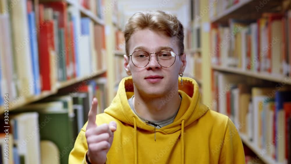 Portrait of nice smart student or young businessman speaking on online video job interview or coach conference smiling at camera staying at library.