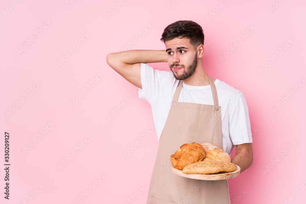 Young caucasian baker man isolated touching back of head, thinking and making a choice. Young caucasian baker man isolated touching back of head, thinking and making a choice.
