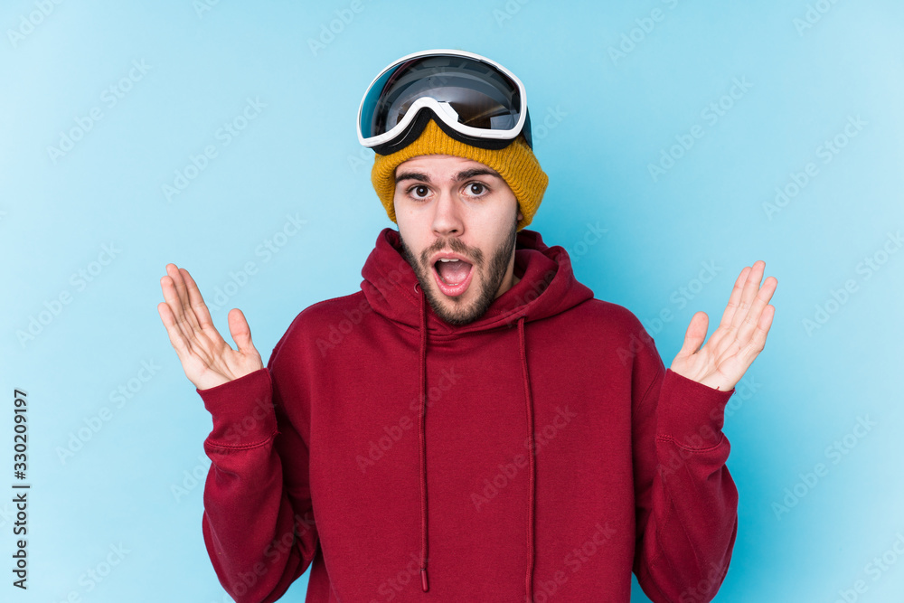 Fototapeta premium Young caucasian man wearing a ski clothes isolated surprised and shocked.