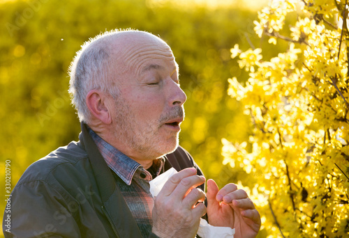 Senior man having allergy symptoms in springtime